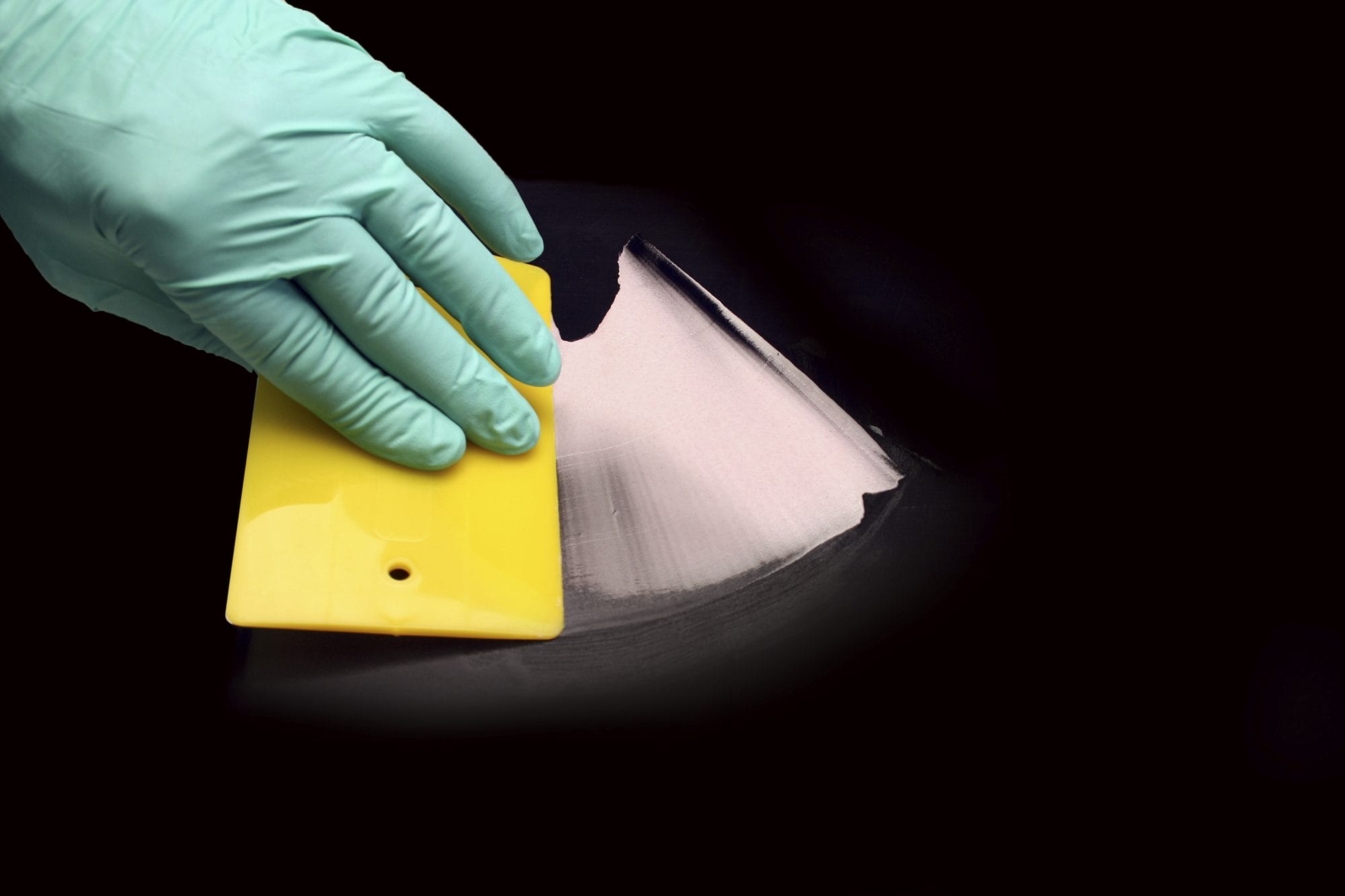 spreading epoxy on a dark surface