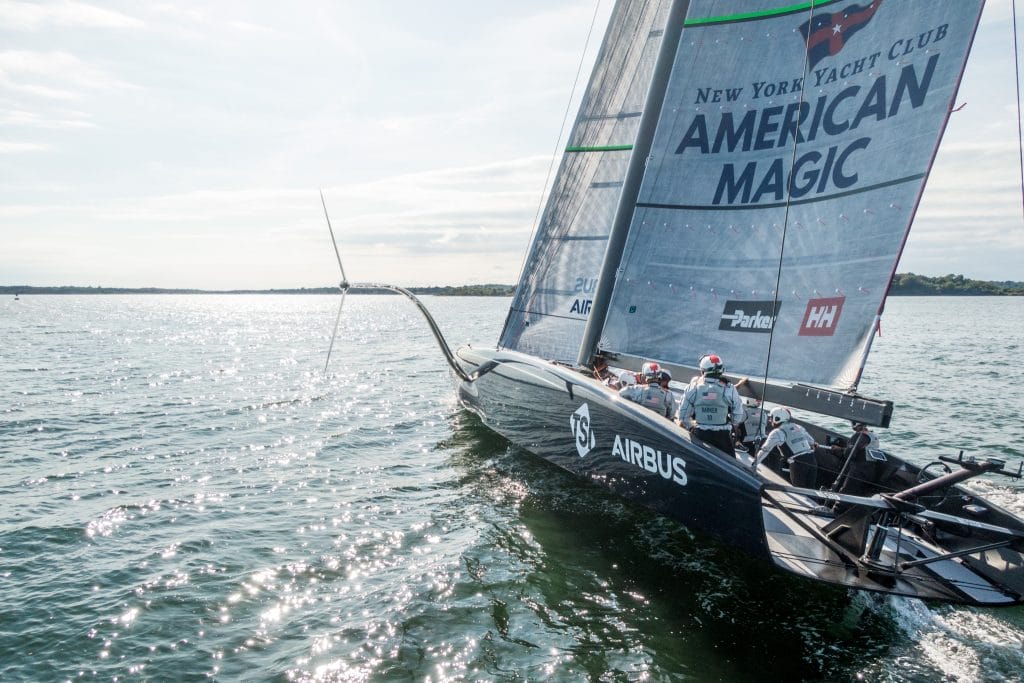 Racing Sailing boats glides across the water with a team aboard