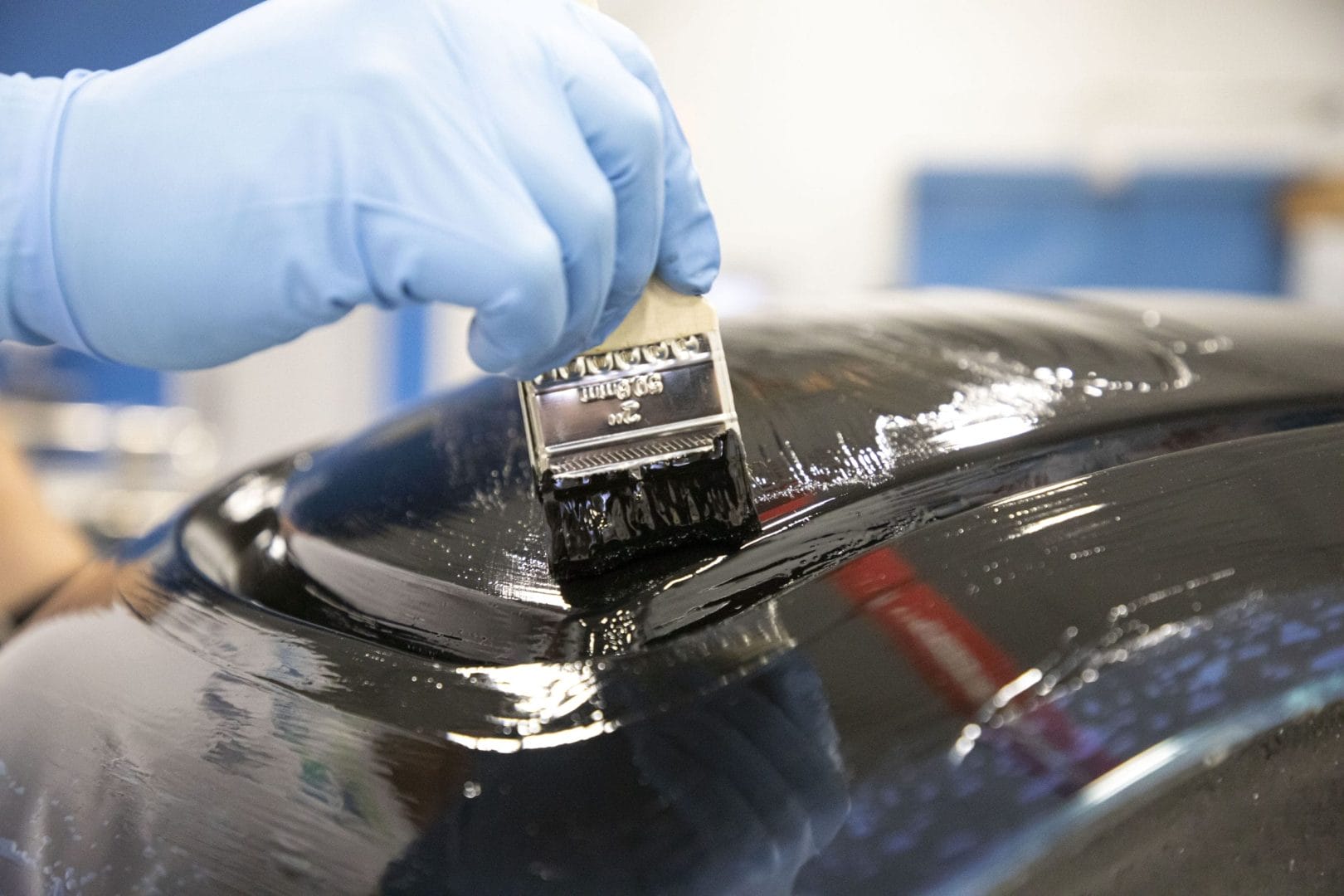 Person applies epoxy coating while protected by gloves.