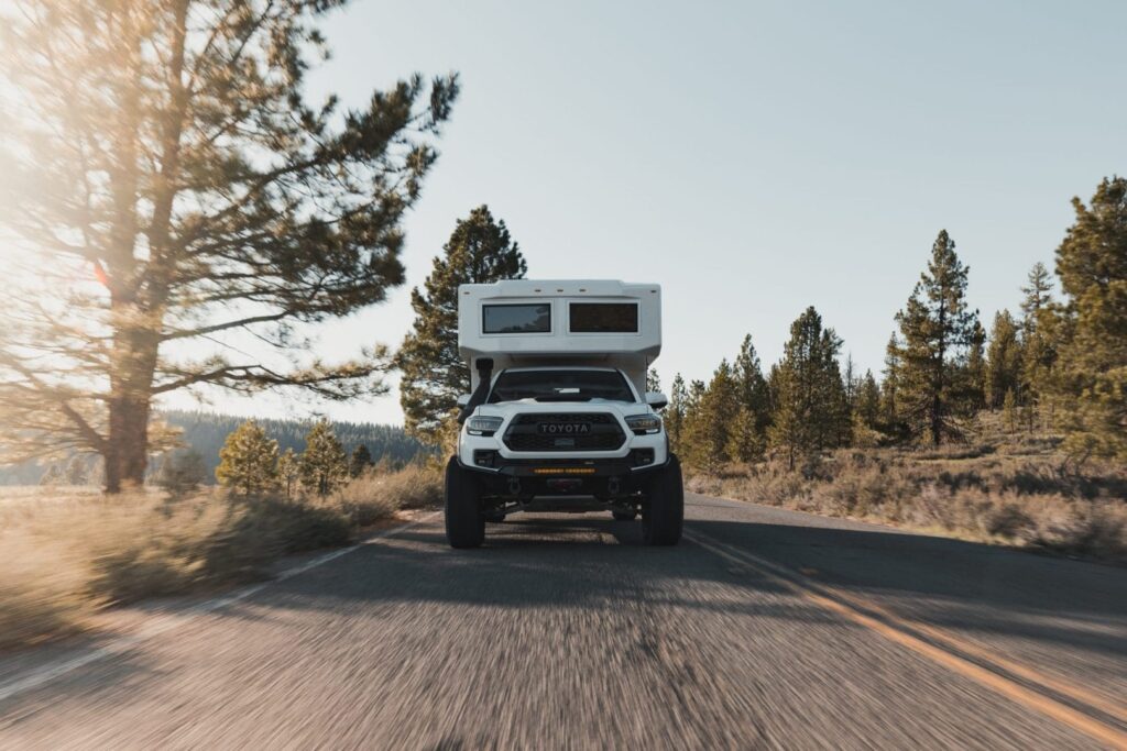 White Camper attached to White Pick Up truck