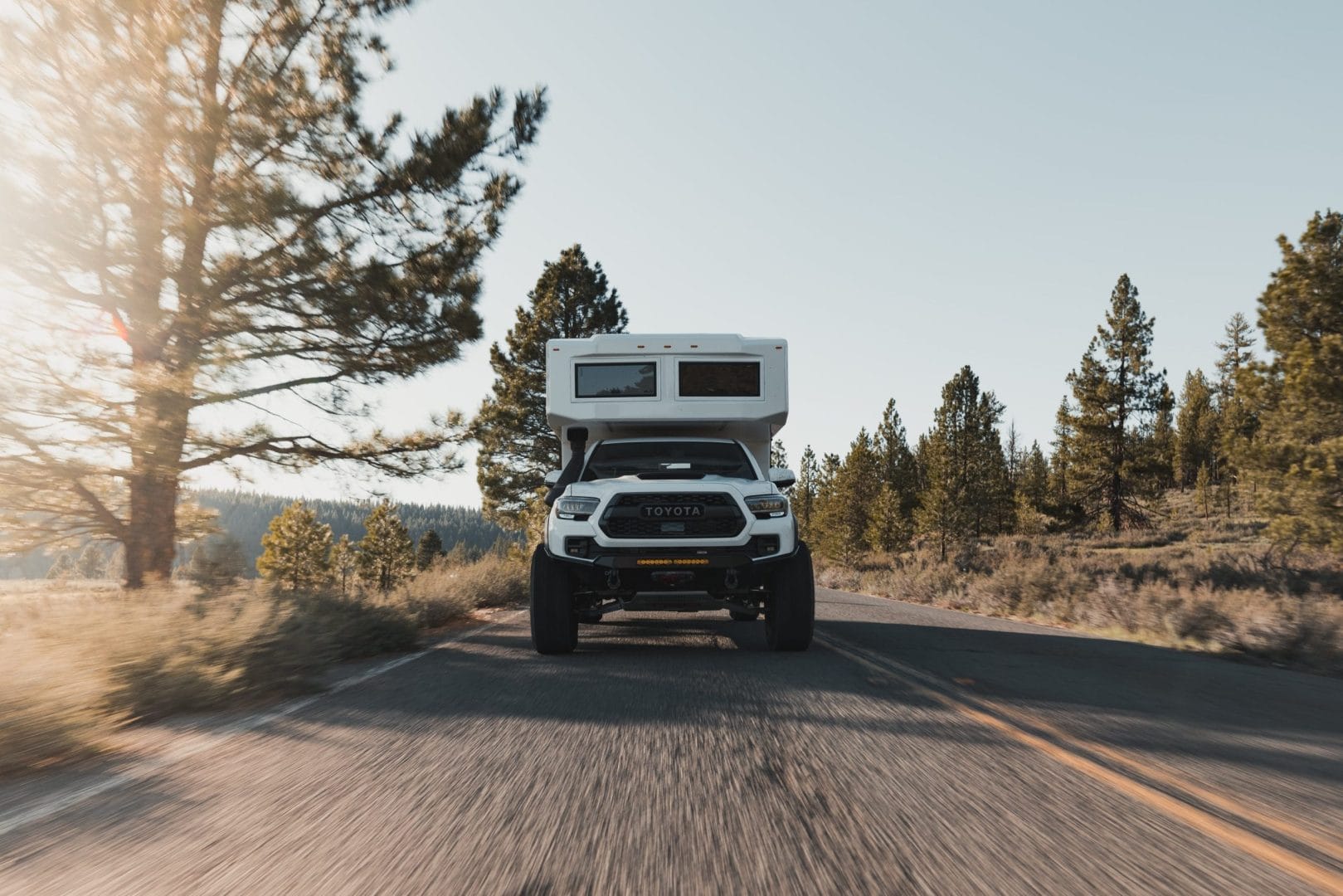 White Camper attached to White Pick Up truck